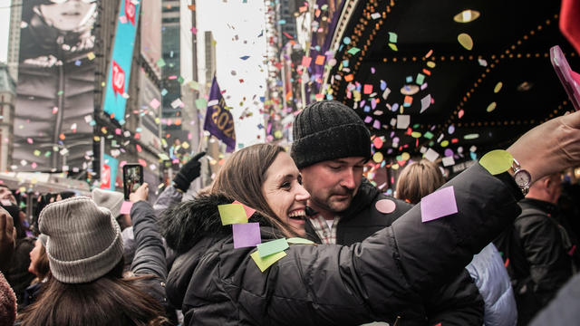 People take a picture of confetti as it's thrown from the Hard Rock Cafe marquee as part of the annual confetti test ahead of the New Year's Eve ball-drop celebrations in Times Square in New York City December 29, 2019. 