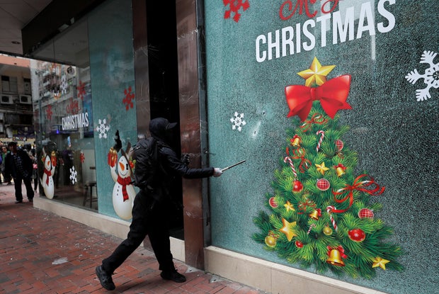 An anti-government protester vandalizes a bureau of the China Life Insurance Company during a demonstration on New Year's Day to call for better governance and democratic reforms in Hong Kong, China, January 1, 2020.