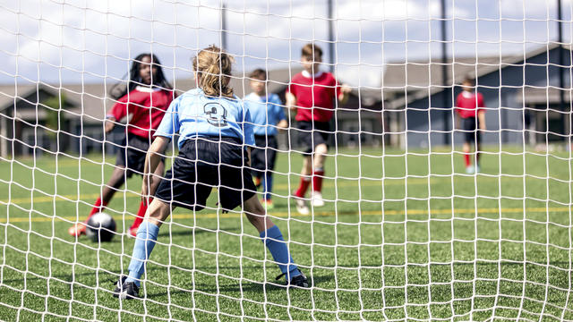 Mixed gender soccer team makes a goal attempt 