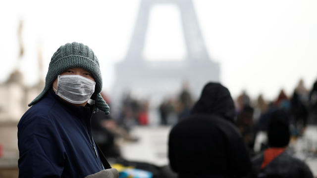 A man wears a face mask on the Trocadero esplanade in front of the Eiffel Tower in Paris, France, January 25, 2020. 