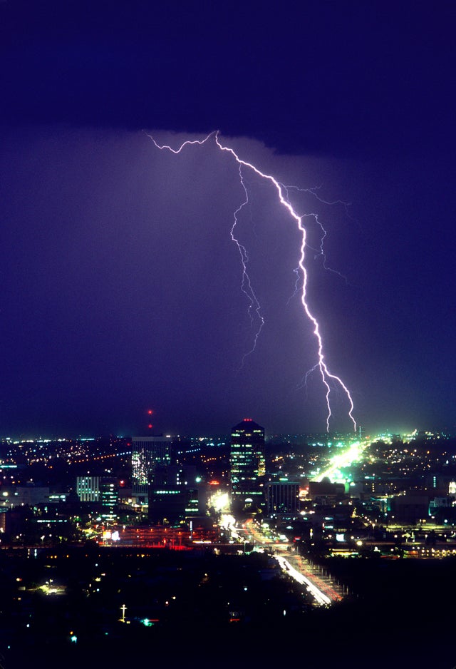 Storm over downtown Tucson, with two cloud-to-ground lightning strike points Tucson, Arizona, USA