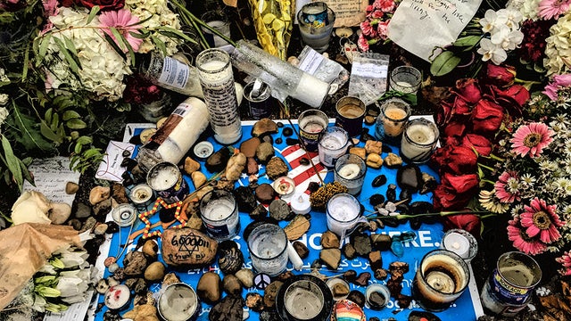 Close-up-of-memorial-stones-candles-and-flowers-photo-by-Brian-Cohen.jpg 