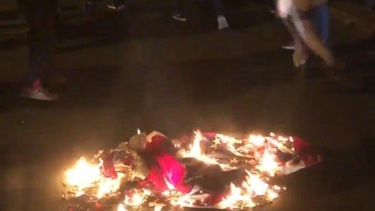 us-flag-burning-during-protest-after-police-shooging-in-raleigh-nite-of-031020.jpg 