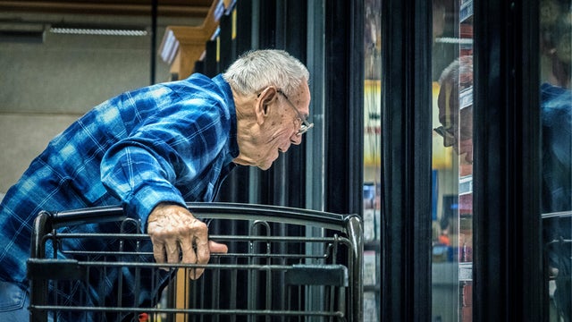 Elderly Man Supermarket Grocery Shopper Looking Through Refrigerated Section Cooler Window 