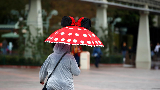 A person walks by Disneyland theme park in Anaheim 