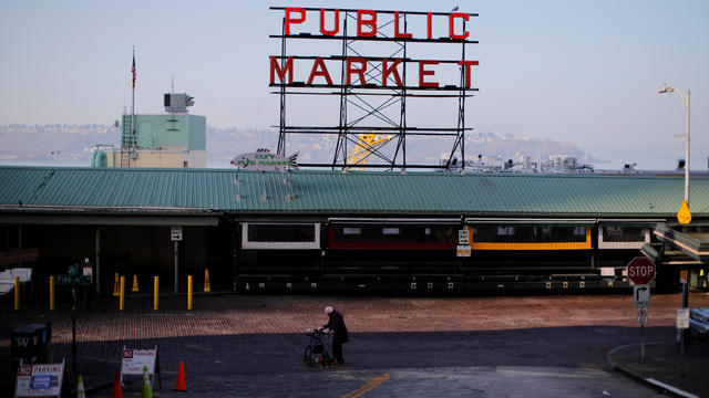 A woman walks through empty streets outside the Public Market, amid the coronavirus disease outbreak, in Seattle 