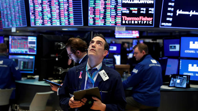 FILE PHOTO: Traders work on the floor of the New York Stock Exchange (NYSE) as the building prepares to close indefinitely due to the coronavirus disease (COVID-19) outbreak in New York 