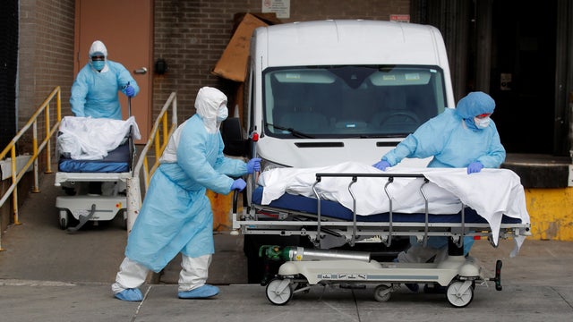 Healthcare workers wheel bodies deceased people from Wyckoff Heights Medical Center during outbreak of coronavirus disease (COVID-19) in New York 