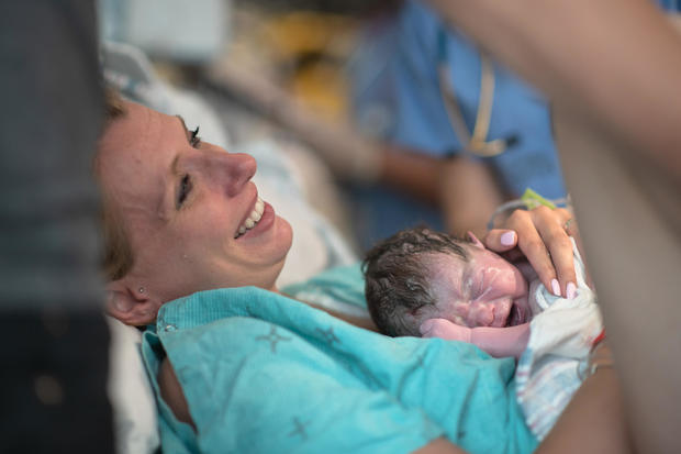 A Mother Holding her Newborn Baby in the Delivery Room for the First Time stock photo 