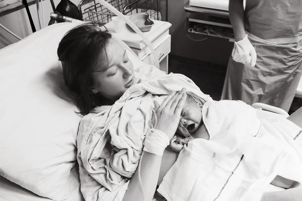 Mother holding her newborn baby child after labor in a hospital. 