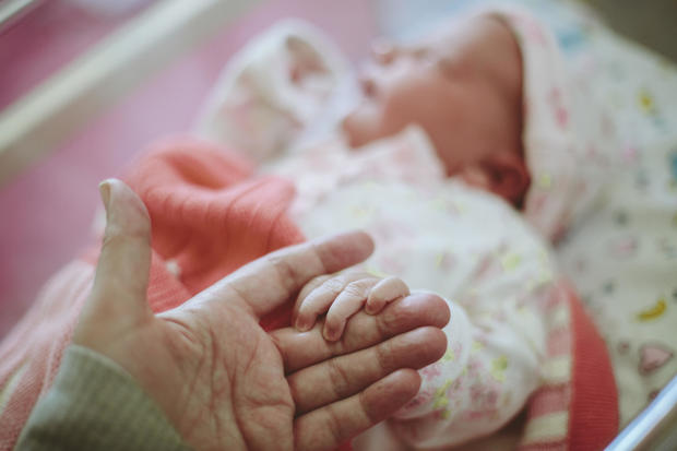 Newborn baby holding Mothers hand 