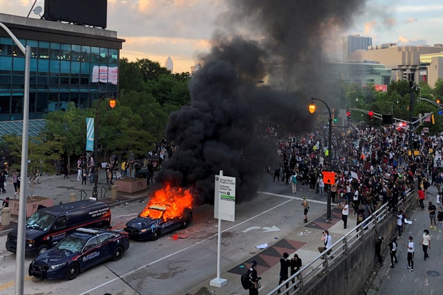 An Atlanta Police car burns as people protest near CNN Center in Atlanta 