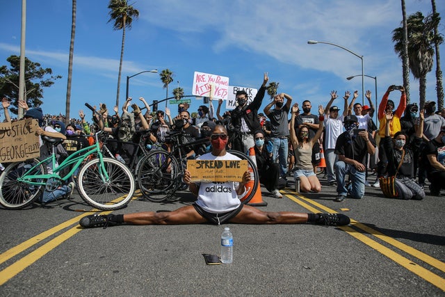 A protester sits with his legs completely spread on the