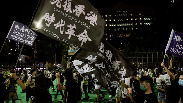 Protesters hold flags while chanting slogans during the 31st 