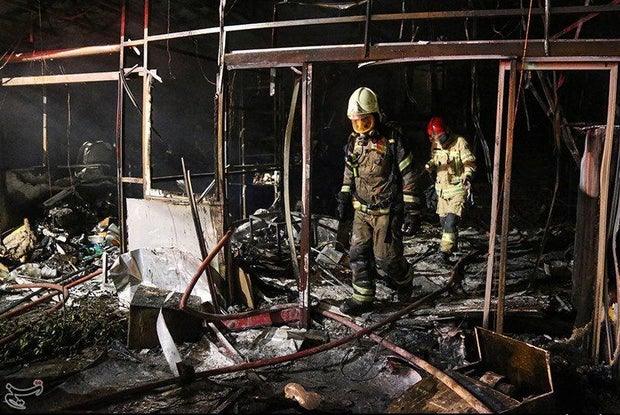 Firefighters inspect the site of an explosion at a medical clinic in the north of the Iranian capital Tehran