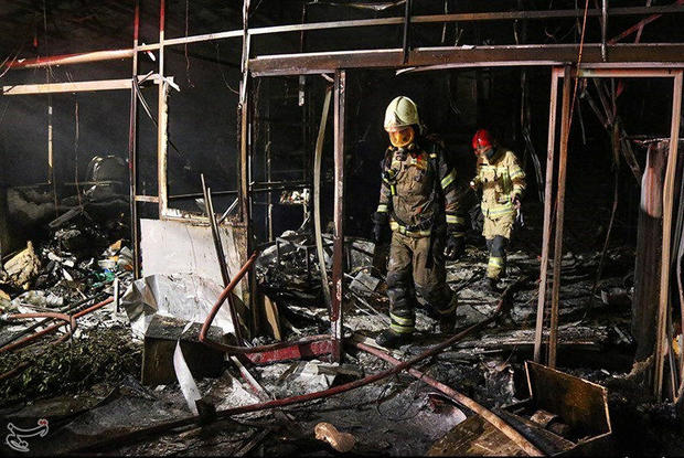 Firefighters inspect the site of an explosion at a medical clinic in the north of the Iranian capital Tehran 