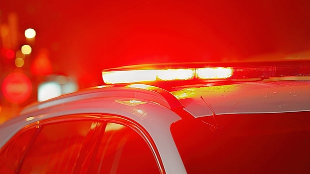 Blue and red lights on top of police car. Night time. 