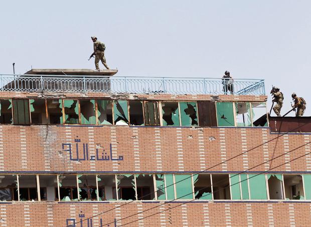 Afghan security forces take position on a building after an attack on a jail compound in Jalalabad 