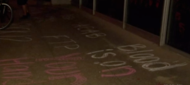 "Blood is on your hands" in paint on the sidewalk 