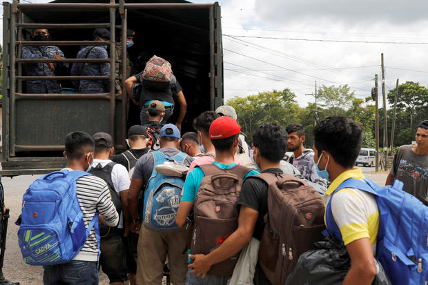 Honduran migrants trying to reach the U.S. get inside a truck escorted by the Guatemalan soldiers to send them back to Honduras, in Morales 