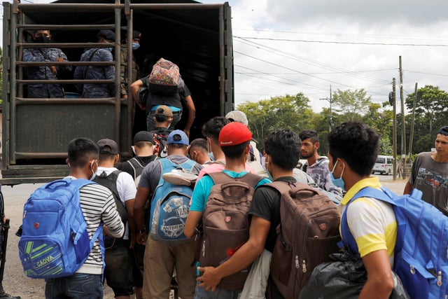 Honduran migrants trying to reach the U.S. get inside a truck escorted by the Guatemalan soldiers to send them back to Honduras, in Morales