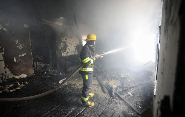 A firefighters extinguishes a fire in a house caused by shelling in the fighting over the breakaway region of Nagorno-Karabakh in the town of Barda 