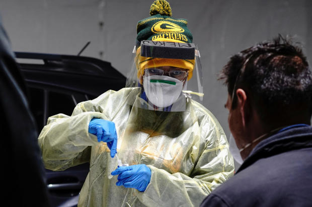 Certified nursing assistant Shameka Johnson, wearing Green Bay Packers apparel, processes a nasal swab at a drive-thru testing site outside the Southside Health Center as the coronavirus disease outbreak continues in Milwaukee, Wisconsin, October 21, 2020 
