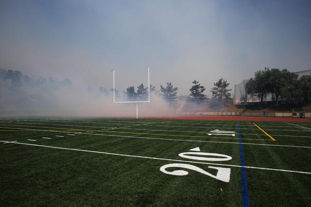 Fire burns in the brush near the football field of Northwood 