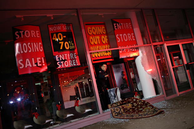 A police officer investigates inside a store that was looted in Philadelphia, Pennsylvania 