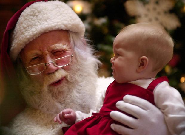Santa Claus grimaces as Molly Powell,8mos., starts to cry after having her picture taken at Park Meadows Mall. Shoppers hit the malls the day after Thanksgiving to catch special prices at retails shops. 