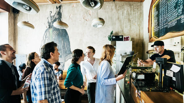 People Waiting In Line In Busy Burger Restaurant 