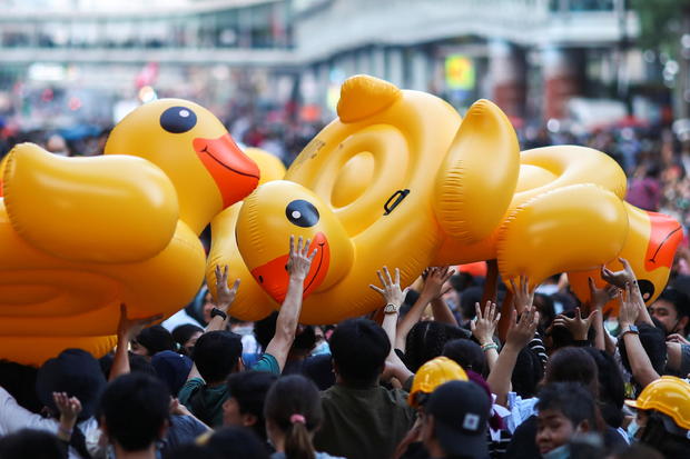 Demonstrators carry inflatable rubber ducks during a rally in Bangkok 
