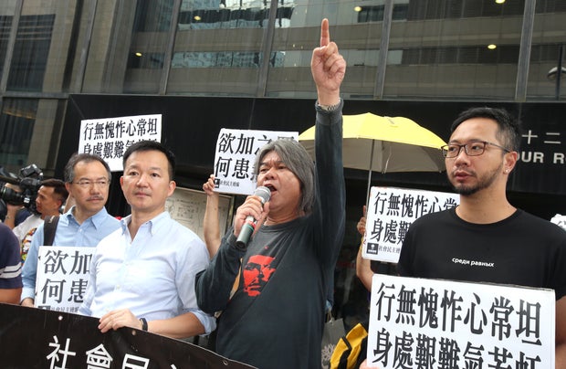 Accompanied by fellow lawmakers Fernando Cheung Chiu-hung (first left), Raymond Chan Chi-chuen (second left) and activist Ken Tsang Kin-chiu (1st right), lawmaker Leung Kwok Hung (L3) (aka Long Hair) appears at Wan Chai District Court in Wan Chai. Leung