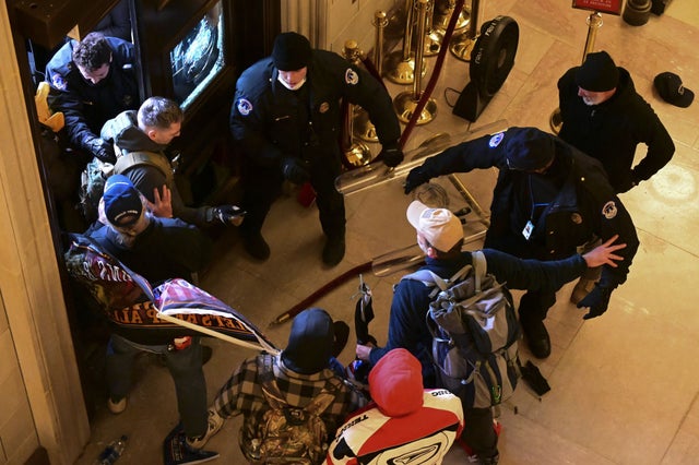 Demonstrators breach a door of the U.S. Capitol as a joint session of Congress counts the votes of the 2020 presidential election on Wednesday, Jan. 6, 2021.