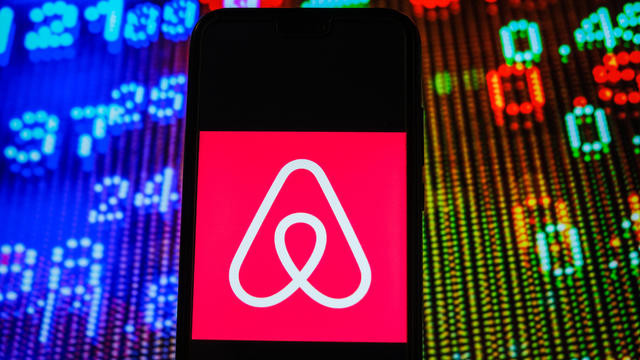 In this photo illustration, an Airbnb logo seen displayed on 