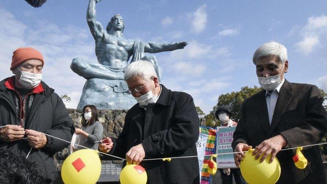 Participants deflate balloons in hope of neutralizing and demolishing nuclear warheads, during a memorial gathering at Peace Park in Nagasaki, southern Japan Friday, Jan. 22, 2021. 