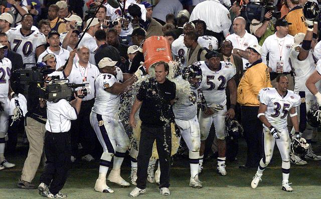 Baltimore Ravens head coach Brian Billick holds the Lombardi Trophy after  defeating the New York Giants, 34-7, to win Super Bowl XXXV as linebacker  Ray Lewis, the game's MVP, right, speaks with