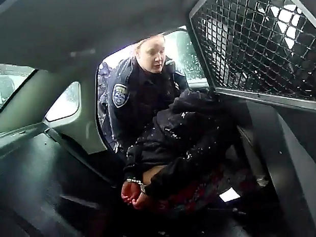 A Rochester police officer asks a handcuffed 9-year-old girl to get into a patrol car prior to the girl being sprayed with pepper spray in a still image from bodycam video taken in Rochester, New York, January 29, 2021. 
