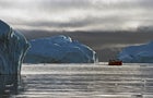 Boat in the water near a Greenland iceberg 