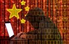 Chinese hacker at work in front of red flag 