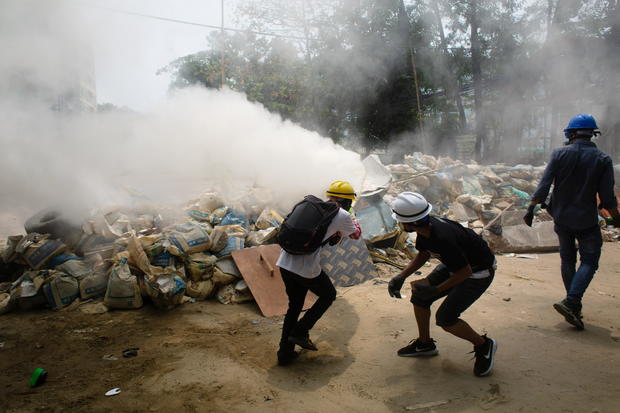 Protesters use fire extinguishers during a protest against the military coup in Yangon 