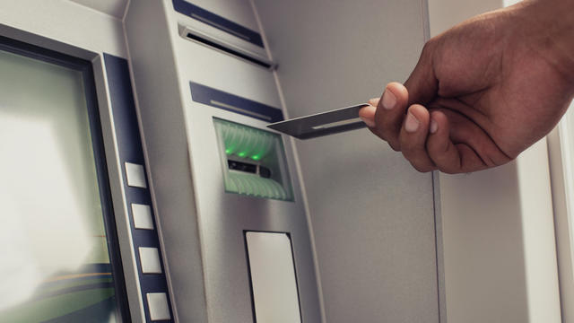 Close up of unrecognizable person with credit card on ATM. 