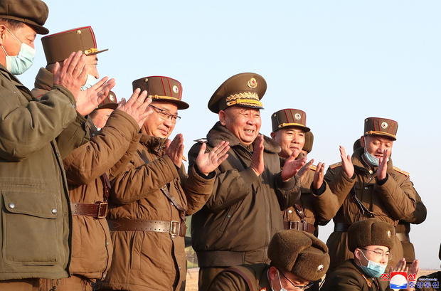 Ri Pyong Chol, the senior leader who is overseeing the test, and other military officials applaud after the launch of a newly developed new-type tactical guided projectile 