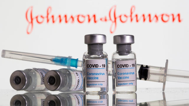 FILE PHOTO: FILE PHOTO: Vials labelled "COVID-19 Coronavirus Vaccine" and sryinge are seen in front of displayed J&J logo in this illustration 