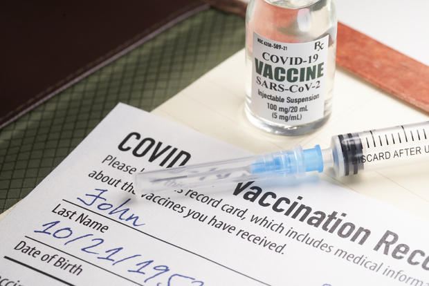 Covid-19 vaccination record card proof vaccine with syringe and vial 