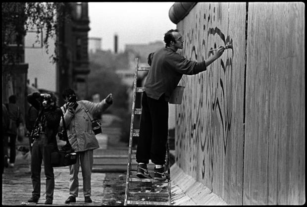 Actor Keith Haring painting the wall nearby Checkpoint Charlie. West-Berlin 1986 