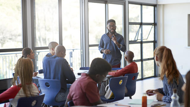 Confident young male professor explaining students 