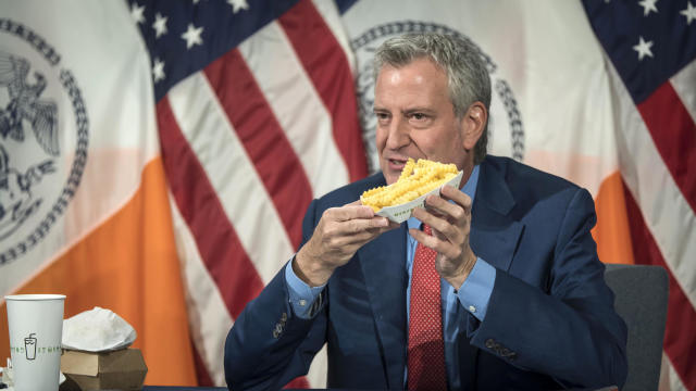 New York Mayor Bill de Blasio holds up a side of Shake Shack fries at City Hall on May 13, 2021. 