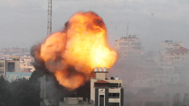 Smoke and flames are seen following an Israeli air strike on a building, amid a flare-up of Israeli-Palestinian fighting, in Gaza City 