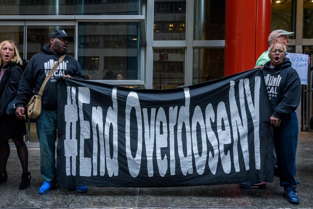Protesters using a banner blocking access to the building in